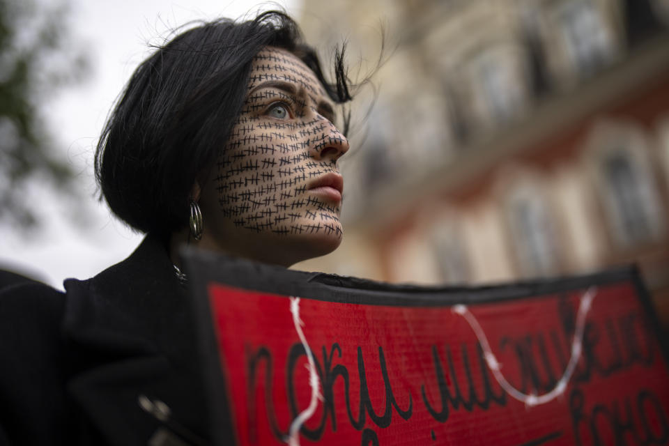 A woman holds a "Free Azov" sign during a rally aiming to raise awareness on the fate of Ukrainian prisoners of war in Kyiv, Ukraine, Sunday, April 21, 2024. (AP Photo/Francisco Seco)