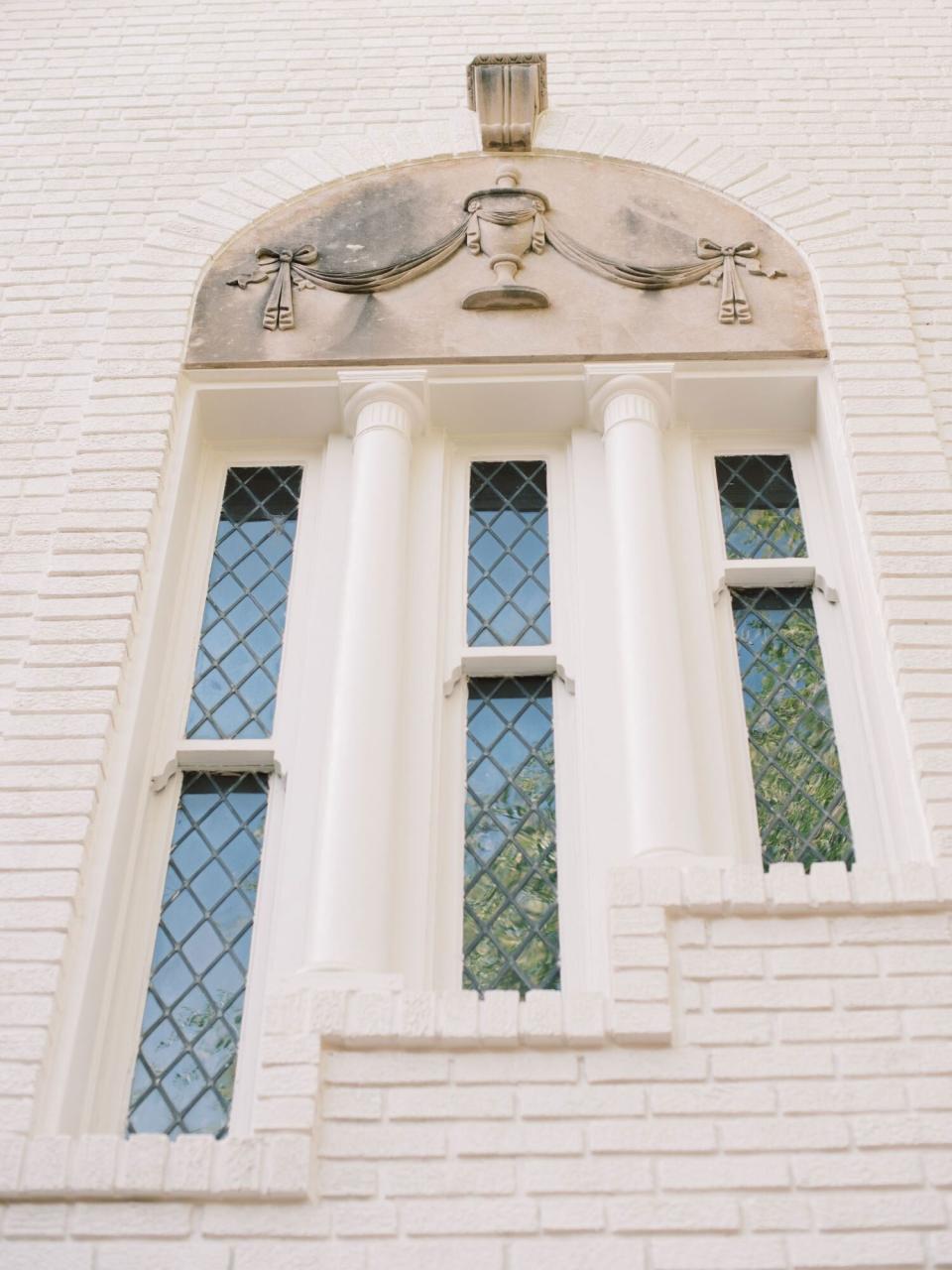 Historic Windows with Ornamental Cast Stone Fixture on Home Exterior