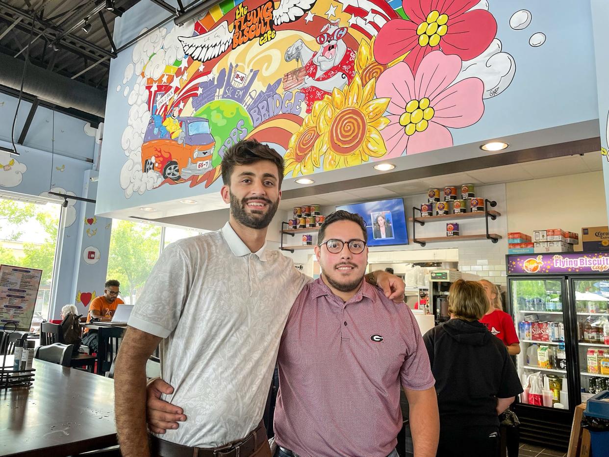(L-R) Arjun Patel and Jhonmark Solis celebrate opening day of their Flying Biscuit Café restaurant at Epps Bridge Road on Monday, July 3, 2023. Patel and Solis are the co-owners of the Epps Bridge and Prince Avenue Flying Biscuit locations.