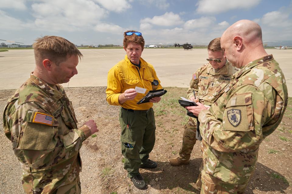 Erin Doyle, a wildfire operations specialist for the City of Boulder Fire Rescue, talks to the crew flying a Lakota helicopter before the training exercise Sunday.