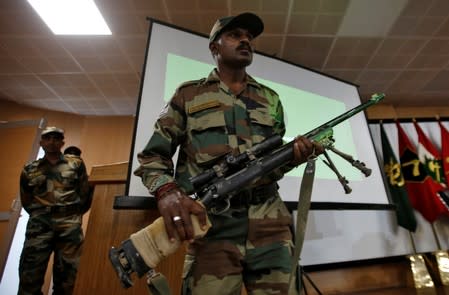 An Indian Army soldier displays a seized rifle during a news conference in Srinagar