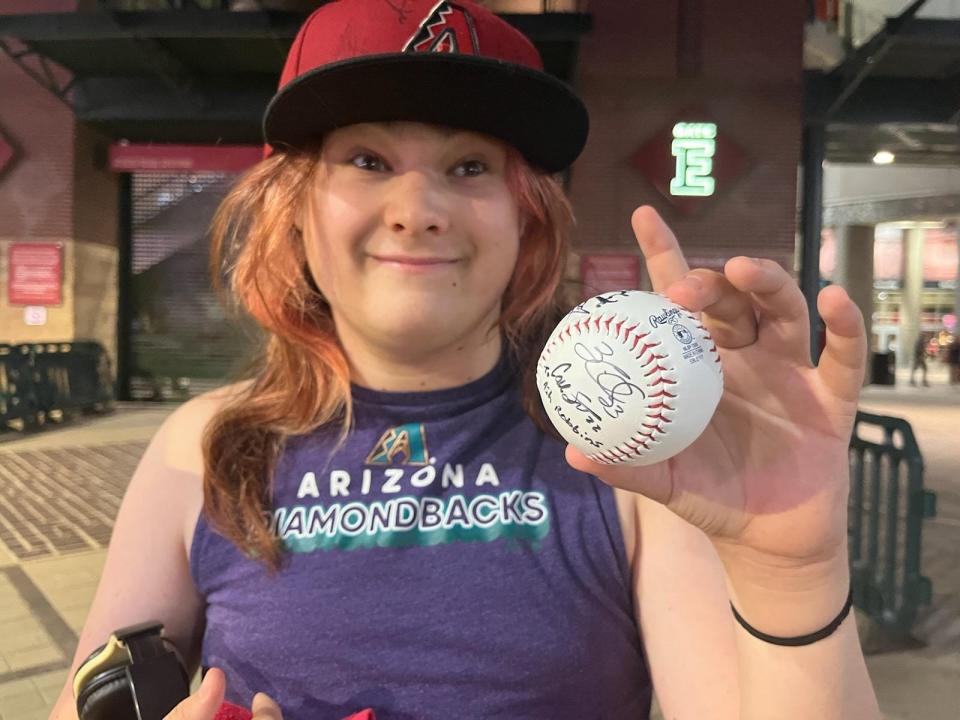 Ashley Robbins shows off the signed baseball which she and her aunt tried to add more signatures to at Game 4, but with no luck, on Oct 20, 2023.