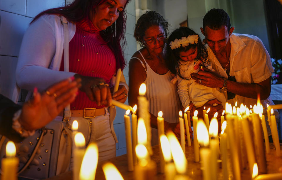 La gente enciende velas en honor a la santa patrona de Cuba, la Virgen de la Caridad del Cobre, en su santuario en El Cobre, Cuba, el domingo 11 de febrero de 2024. (AP Foto/Ramón Espinosa)