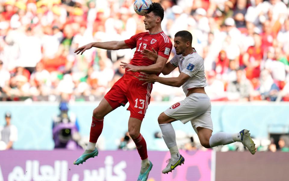 Wales' Kieffer Moore, left, and Iran's Majid Hosseini go for a header during the World Cup group B soccer match between Wales and Iran, at the Ahmad Bin Ali Stadium - AP