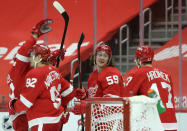 Detroit Red Wings left wing Tyler Bertuzzi (59) celebrates with center Vladislav Namestnikov (92) and defenseman Filip Hronek (17) after scoring the game-winning goal in overtime to defeat the Columbus Blue Jackets in an NHL hockey game Tuesday, Jan. 19, 2021, in Detroit. (AP Photo/Duane Burleson)