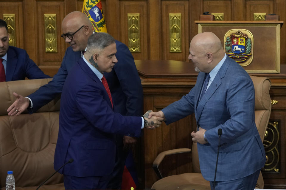 Karim Khan, chief prosecutor of the International Criminal Court, right, shakes hands with Venezuelan General Attorney Tarek William Saab after a meeting at the National Assembly in Caracas, Venezuela, Monday, April 22, 2024. Behind is Jorge Rodriguez, National Assembly president. (AP Photo/Ariana Cubillos)