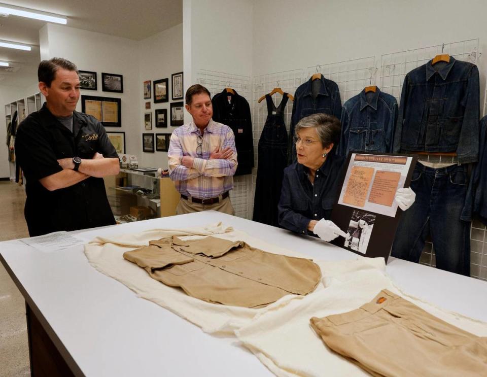Archivist Ann Richardson talks about a work suit of shirt and pants as Dickies Global Brand President Todd Dalhausser and brand ambassador Philip Williamson look on at Dickies Quality Workwear and Apparel offices in downtown Fort Worth Texas, Thursday Mar. 28, 2024. The apparel was returned to the company by the original purchaser. It was worn 14 years. He thought it would be a good advertisement to the company and hoped they would send him a replacement.