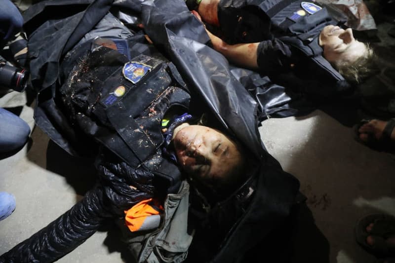 Bodies of the deceased officials of the US-based international volunteer aid organization World Central Kitchen (WCK), can be seen on the ground following an Israeli attack on a WCK vehicle in Deir Al-Balah. Omar Ashtawy/APA Images via ZUMA Press Wire/dpa