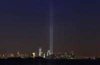 The Tribute in Light is illuminated next to the Statue of Liberty (C) and One World Trade Center (L) during events marking the 12th anniversary of the 9/11 attacks on the World Trade Center in New York, September 10, 2013. (REUTERS/Gary Hershorn)