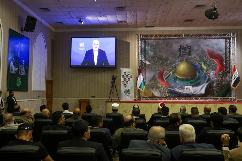 Religious clerics with supporters of Iraqi Shi'ite armed groups watch a televised speech by Hamas chief Ismail Haniyeh, ahead of Al-Quds (Jerusalem) Day, in Baghdad