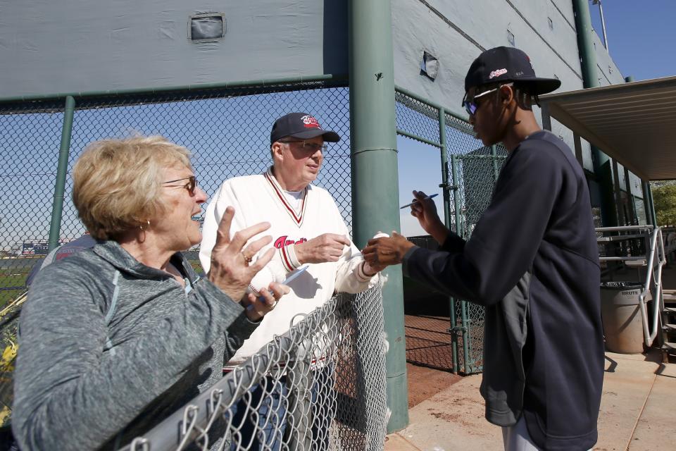 Cleveland Indians pitcher Triston McKenzie, right, gives autographs to fans during spring training baseball workouts for pitchers and catchers Friday, Feb. 14, 2020, in Avondale, Ariz. (AP Photo/Ross D. Franklin)