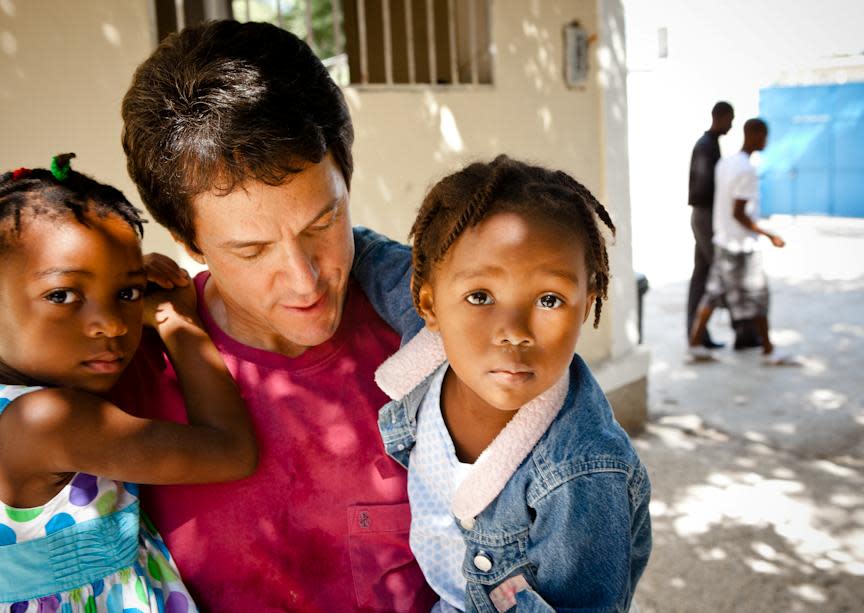 Author Mitch Albom with two of the children living at the orphanage he runs in Haiti.