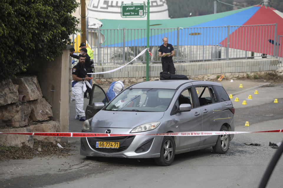 Police examine a car in Umm el-Fahm, Israel, Friday, Dec. 3, 2021, after a man was shot dead by Israeli police in a car-ramming incident, following a night of intense violence in the Arab populated Israeli town. (AP Photo/Mahmoud Illean)