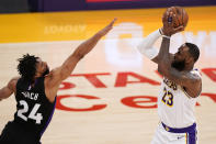 Los Angeles Lakers forward LeBron James, right, shoots as Toronto Raptors center Khem Birch defends during the first half of an NBA basketball game Sunday, May 2, 2021, in Los Angeles. (AP Photo/Mark J. Terrill)