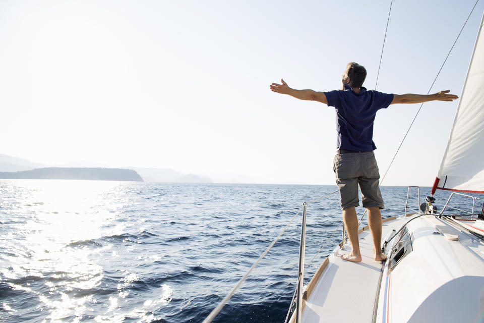 Man with his arms spread on a sailboat