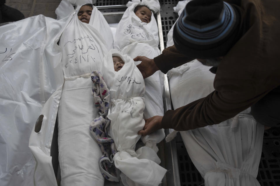 Palestinians mourn their relatives, including kids killed in the Israeli bombardment of the Gaza Strip, outside a morgue in Rafah, southern Gaza, Thursday, Jan. 11, 2024. (AP Photo/Fatima Shbair)