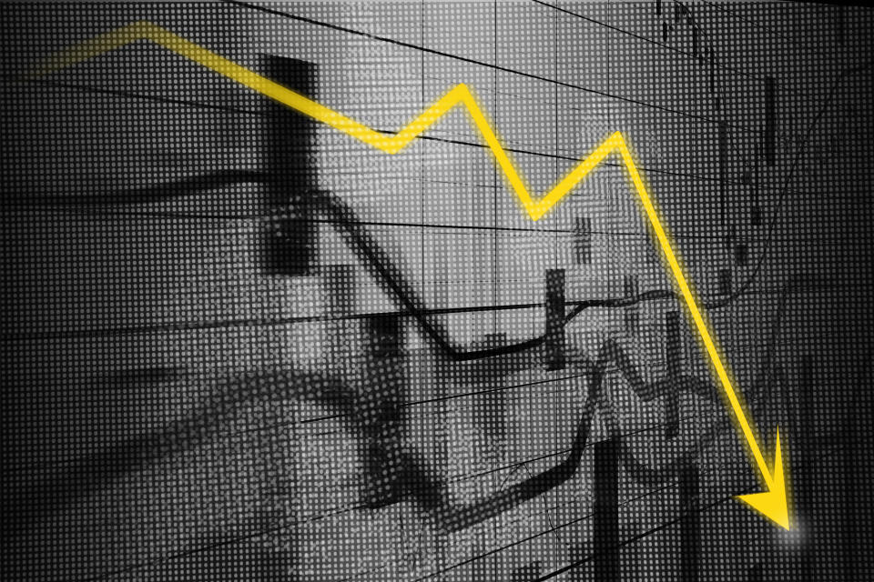 Stock market charts in grey with a yellow arrow line indicating losses.