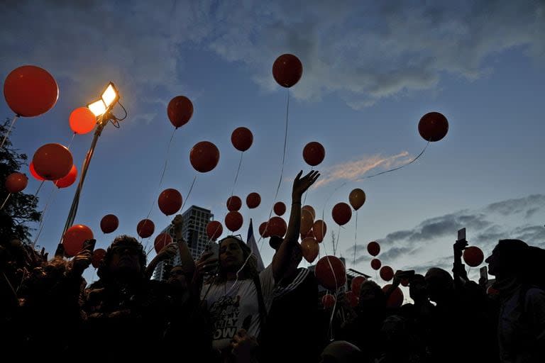 Manifestantes sueltan globos mientras piden la liberación de la familia Bibas, cuyos miembros permanecen secuestrados en la Franja de Gaza por el grupo militante Hamás, en Tel Aviv, martes 28 de noviembre de 2023. 