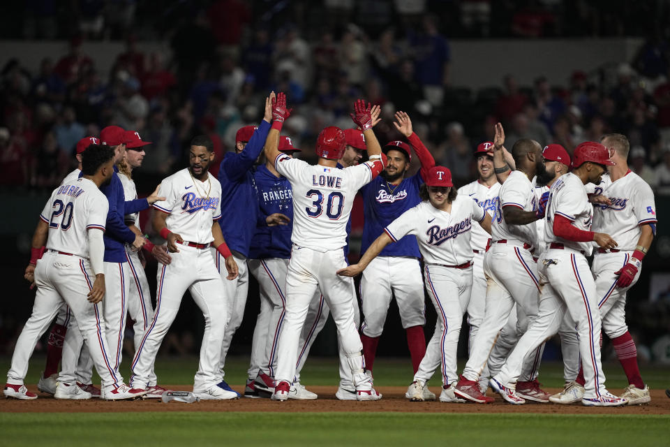 Texas Rangers' Nathaniel Lowe (30) celebrates with teammates after hitting a run-scoring single in the ninth inning of a baseball game against the St. Louis Cardinals, Monday, June 5, 2023, in Arlington, Texas. Marcus Semien scored on the play. (AP Photo/Tony Gutierrez)