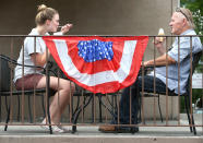 <p>Alexis Mathias of Strasburg, Va. and Dennis Carlyle of Middletown, Va. enjoy a frozen treat at Scoops and Swirls ice cream shop in Middletown, Va. Saturday, July 1, 2017. Much of the town has been decorated by business owners and homeowners for their July 4 parade and fireworks display. (Photo: Jeff Taylor/The Winchester Star via AP) </p>