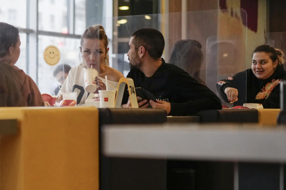 People have a meal in a restaurant in Moscow, Russia, Monday, Nov. 8, 2021. Russian capital had return to work on Monday after nonworking days due to coronavirus. Certain restrictions will remain in place, such as a stay-at-home order for older adults and a mandate for businesses to have 30% of their staff work from home. Access to theatres and museums is limited to those who either have been fully vaccinated, have recovered from COVID-19 within the last six months or can present a negative coronavirus test. (AP Photo/Pavel Golovkin)