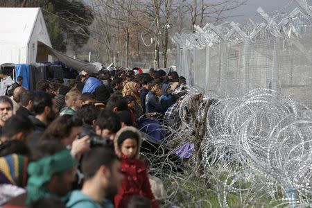 Migrants stand next to the Greek-Macedonian border fence, near the Greek village of Idomenii March 1, 2016. REUTERS/Marko Djurica
