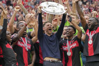 FILE - Leverkusen's head coach Xabi Alonso celebrates with the trophy as his team won the German Bundesliga, after the German Bundesliga soccer match between Bayer Leverkusen and FC Augsburg at the BayArena in Leverkusen, Germany, Saturday, May 18, 2024. A low-rise city of 167,000 that grew up around the factories of the pharmaceuticals giant Bayer, Leverkusen has little to draw tourists besides its internationally famed soccer club. The team finished an entire German Bundesliga season unbeaten Saturday and is now targeting trophies in the Europa League and German Cup. (AP Photo/Martin Meissner, File)