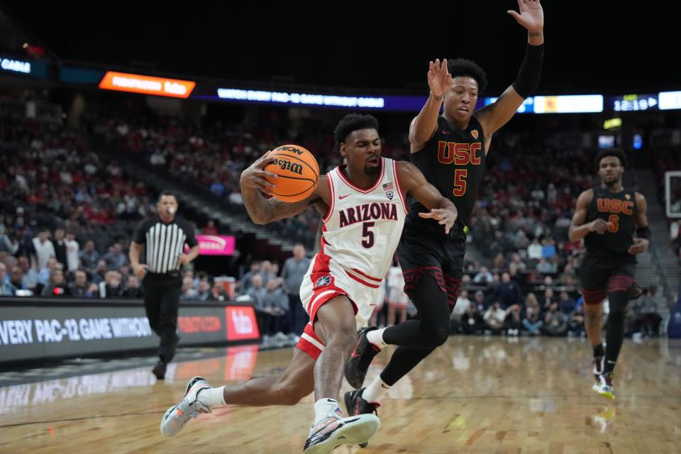 Arizona Wildcats guard KJ Lewis (left) dribbles the ball against Southern California Trojans guard Boogie Ellis in the first half at T-Mobile Arena in Las Vegas on March 14, 2024.