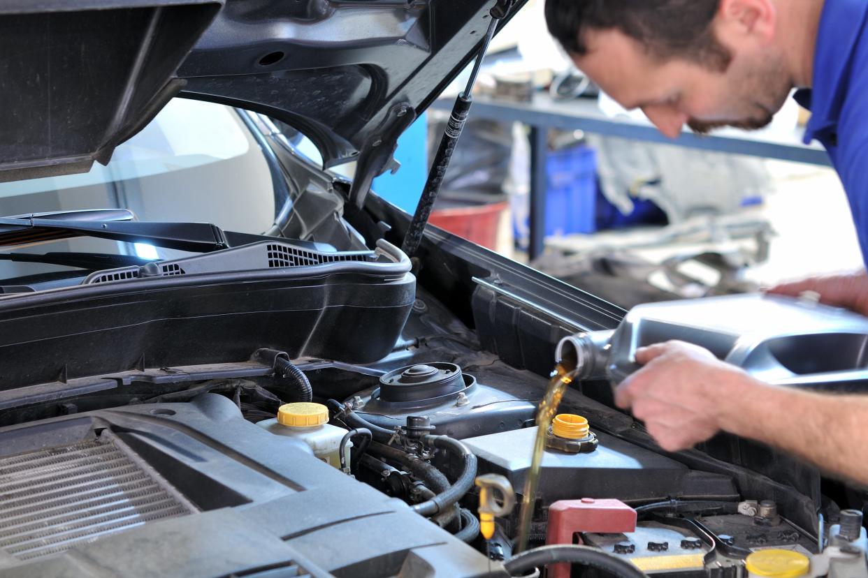 mechanic changing oil in automobile