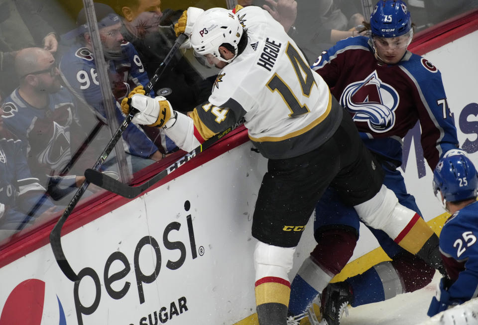 Vegas Golden Knights defenseman Nicolas Hague, left, fights for control of the puck with Colorado Avalanche left wing Sampo Ranta in the third period of an NHL hockey game Tuesday, Oct. 26, 2021, in Denver. The Golden Knights won 3-1. (AP Photo/David Zalubowski)
