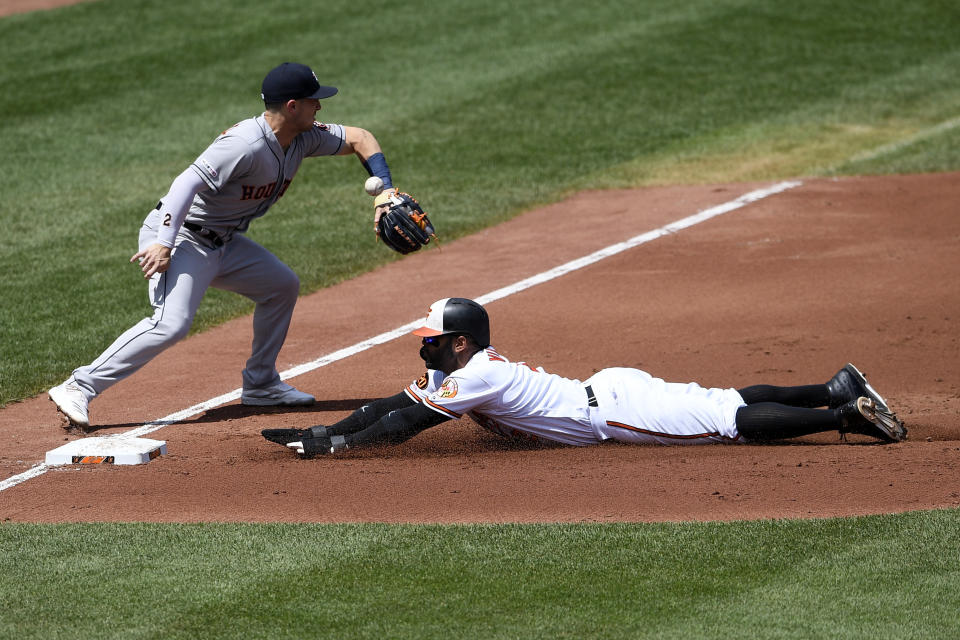 Baltimore Orioles' Jonathan Villar, right, slides into third safely on a single by Trey Mancini against Houston Astros third baseman Alex Bregman, left, during the second inning of a baseball game, Sunday, Aug. 11, 2019, in Baltimore. (AP Photo/Nick Wass)