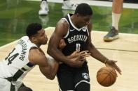 Milwaukee Bucks' Giannis Antetokounmpo and Brooklyn Nets' Reggie Perry battle for a loose ball during the second half of Game 4 of the NBA Eastern Conference basketball semifinals game Sunday, June 13, 2021, in Milwaukee. (AP Photo/Morry Gash)