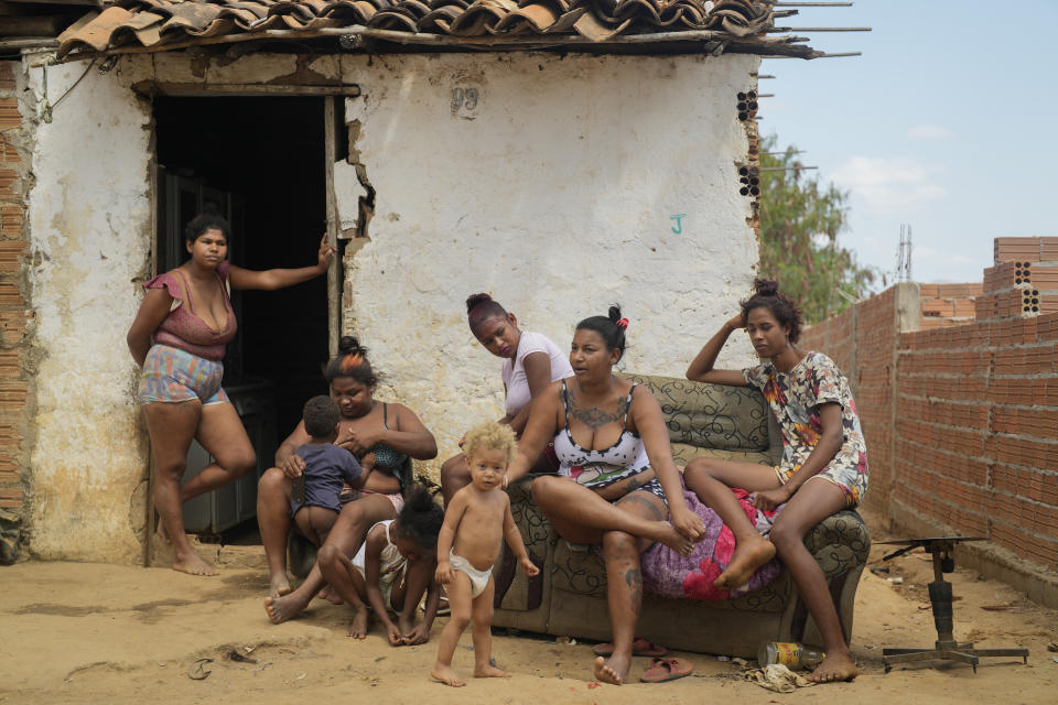 Aglete Batista (segunda desde la derecha) y su familia sentados frente a su casa en Aracuai (Brasil) el 11 de octubre del 2022. En la antesala de la segunda ronda electoral, programada para el 30 de octubre, Batista dice que no se olvida de toda la ayuda que recibió bajo los gobiernos de Lula. (AP Photo/Andre Penner, File)