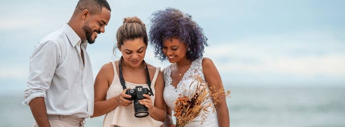 A photographer showing a bride and groom photos on her camera