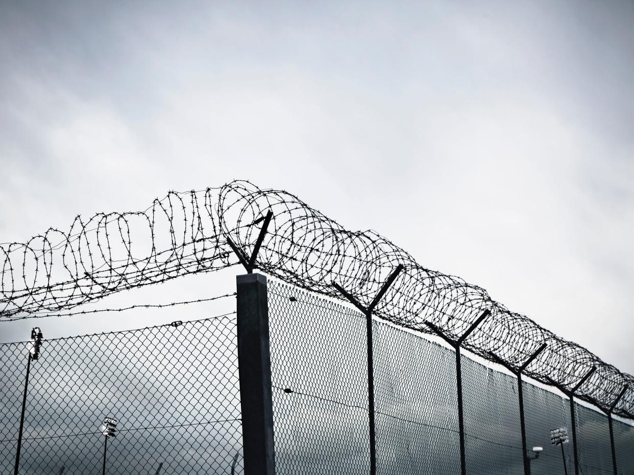 Chain link fence with barbed wire and razor wire.