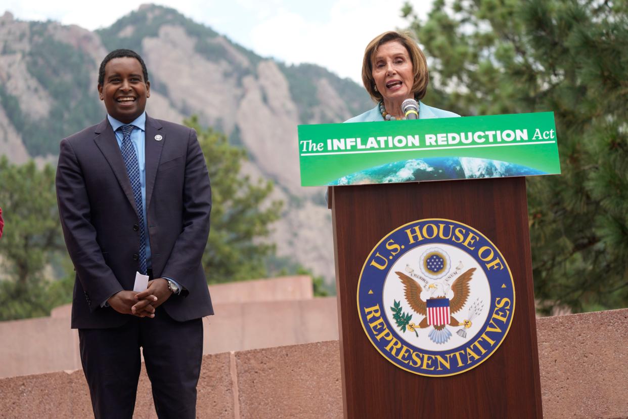 Speaker of the House Nancy Pelosi, D-Calif. (at podium) with U.S. Rep. Joe Neguse, D-Colo. (left) on Aug. 31, 2022, in Boulder, Colo. 