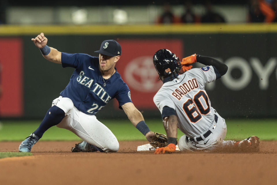 Seattle Mariners shortstop Dylan Moore, left, tags out Detroit Tigers' Akil Baddoo as Baddoo attempts to steal second base during the third inning of a baseball game, Monday, Oct. 3, 2022, in Seattle. (AP Photo/Stephen Brashear)