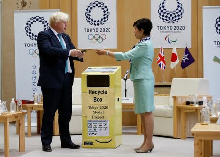 Britain's Foreign Secretary Boris Johnson (L) talks with Tokyo Governor Yuriko Koike before he feeds a smartphone into a box collecting old mobile phones from Tokyo residents, which will be recycled into medals for the 2020 Tokyo Olympics and Paralympics, during their meeting at Tokyo Metropolitan Government buildingin Tokyo, Japan July 21, 2017. REUTERS/Issei Kato