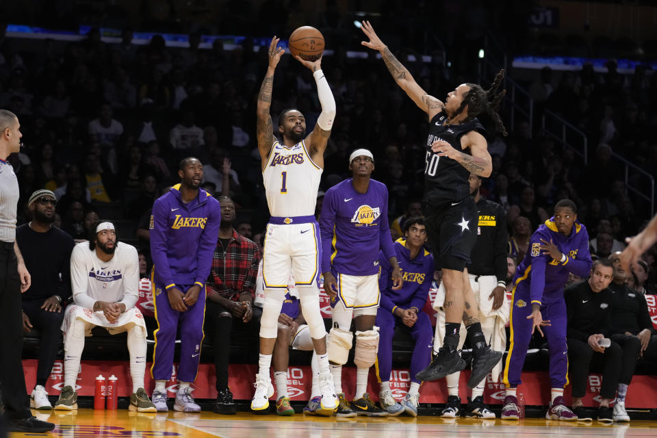 Los Angeles Lakers guard D'Angelo Russell (1) shoots next to Orlando Magic guard Cole Anthony (50) during the first half of an NBA basketball game Sunday, March 19, 2023, in Los Angeles. (AP Photo/Marcio Jose Sanchez)