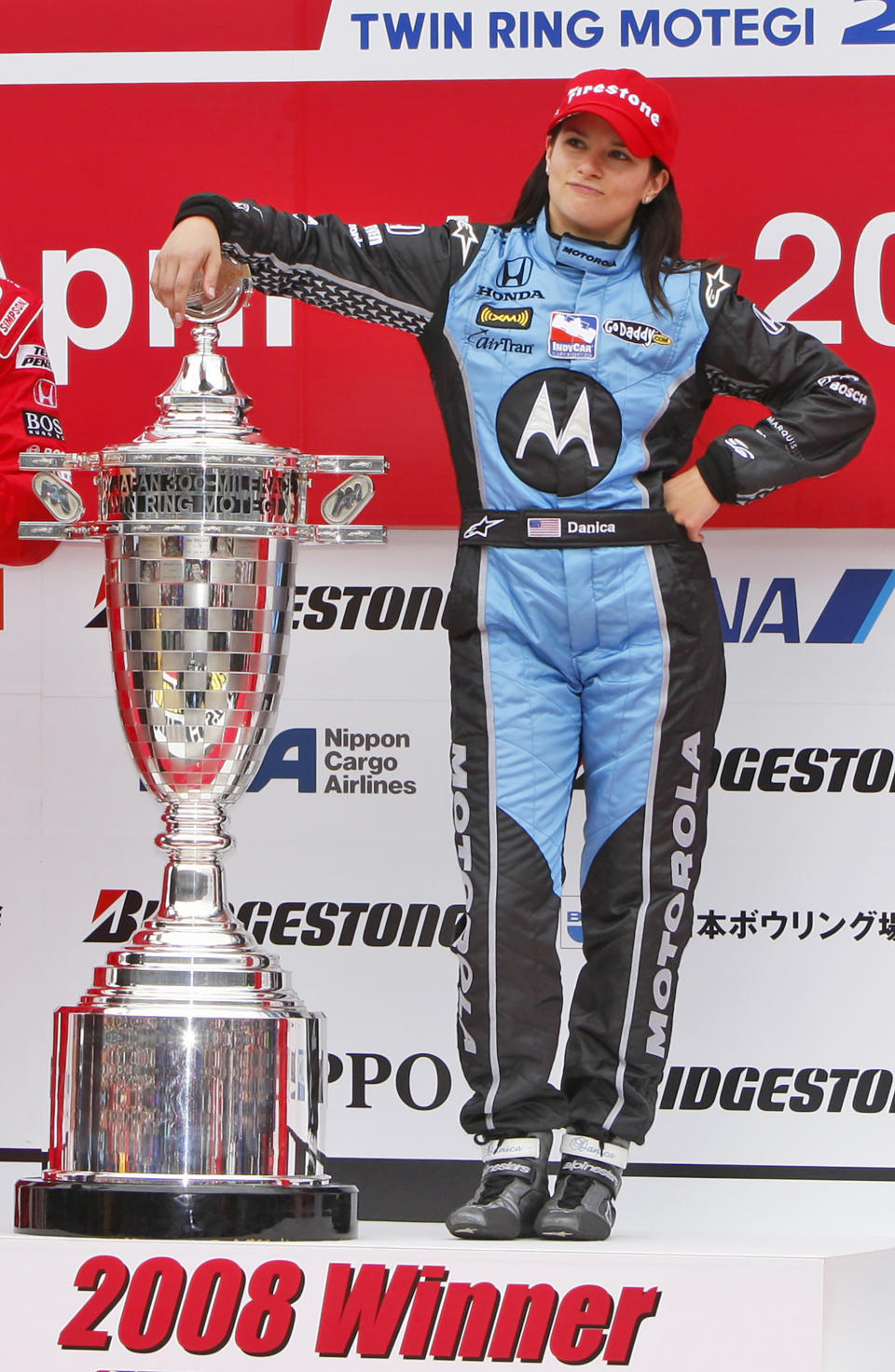 FILE - Danica Patrick of Andretti Green Racing poses with trophy on the podium after winning the Bridgestone Indy Japan 300 mile auto race on the 1.5-mile oval track at Twin Ring Motegi in Motegi, northeast of Tokyo Sunday, April 20, 2008. (AP Photo/Shuji Kajiyama, File)