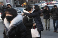 A student hugs her mother, right, before entering a high school to take the college entrance exam in Seoul, South Korea, Thursday, Dec. 3, 2020. South Korean officials urged on Wednesday people to remain at home if possible and cancel gatherings as about half a million students prepare for the crucial national college exam. (AP Photo/Ahn Young-joon)