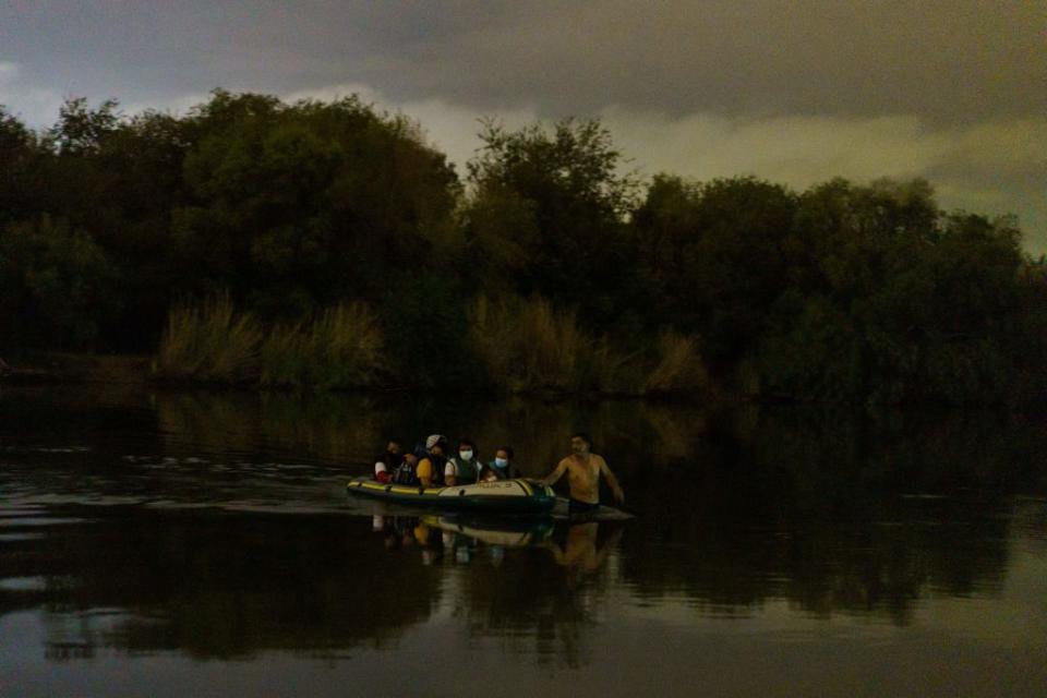 A human smuggler pulls an inflatable raft across the Rio Grande and into the United States on July 7, 2021. <span class="copyright">Paul Ratje—AFP/Getty Images</span>