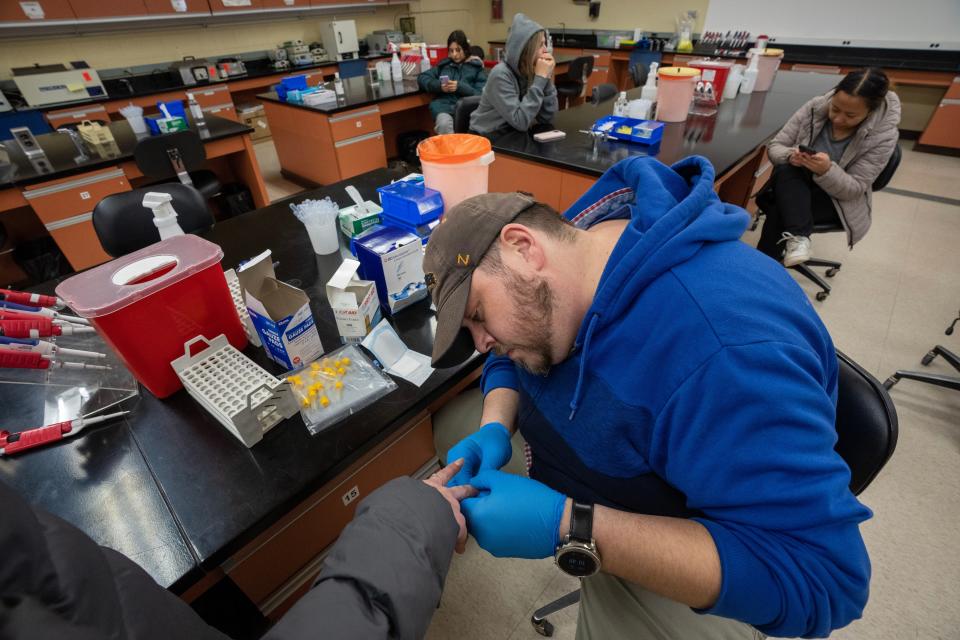 Clinical assistant professor of biomedical sciences Brad De Pons takes a blood sample from a student during a lab in Enderis Hall. Lab space in the building lacks flexibility and is outdated. But funding to move UWM's College of Health Sciences into the Northwest Quadrant didn't make it into Gov. Tony Evers spending plan for capital projects.