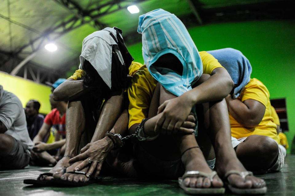 <p>Arrested and surrendered drug dependents and small time peddlers are held in a police gymnasium during a night time mass arrest on August 20, 2016 in Manila, Philippines. (Dondi Tawatao/Getty Images) </p>