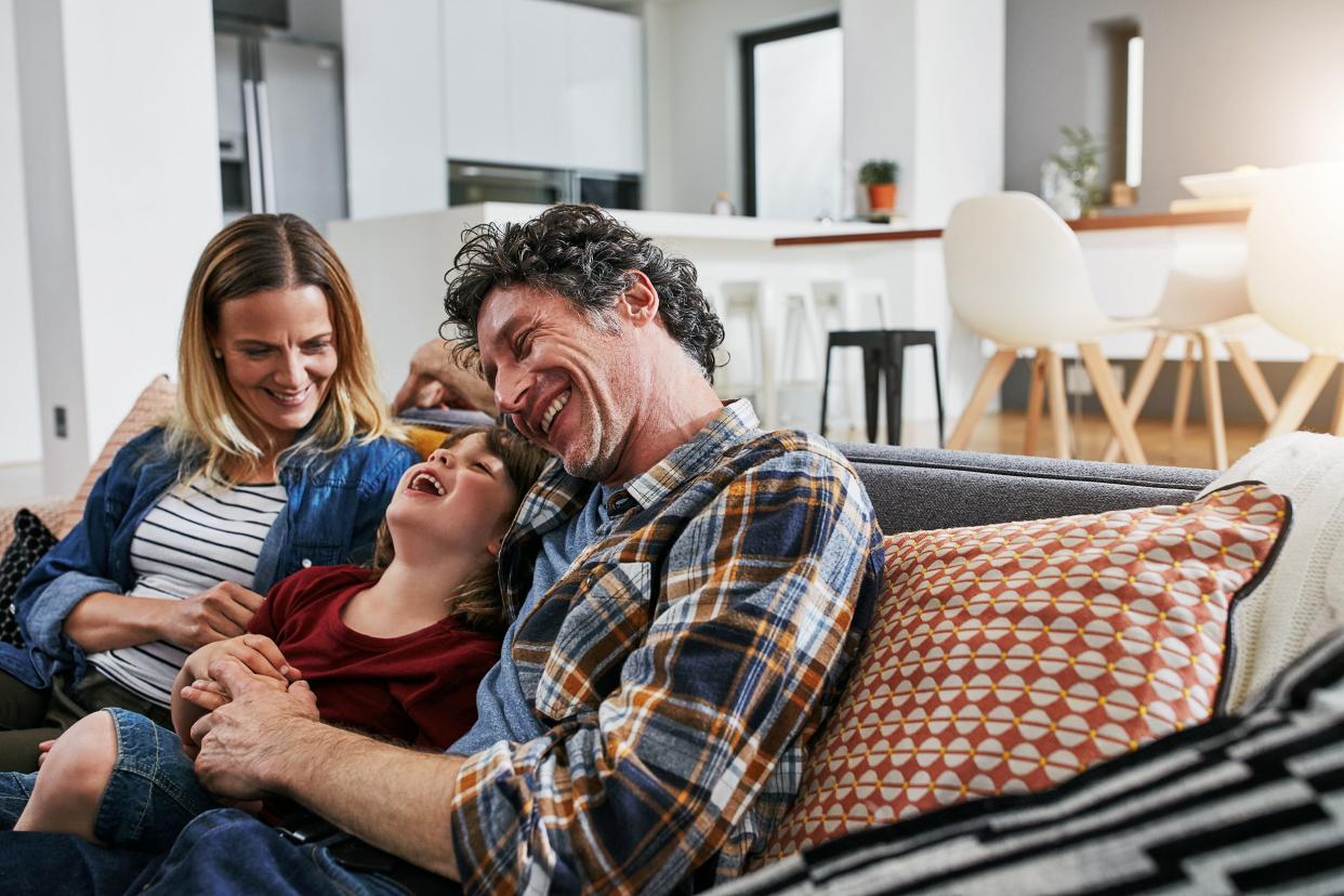 family at home hugging on couch