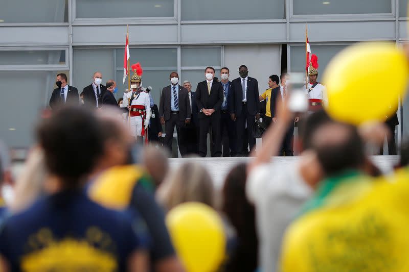 Brazil's President Jair Bolsonaro observes supporters during a demonstration outside Planalto Palace, amid the spread of the coronavirus disease (COVID-19), in Brasilia