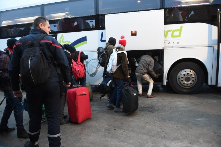 Les bus arrivent enfin. Les migrants chargent leurs bagages avant de s’installer. Le premier véhicule est parti dans la matinée vers 8h45. (AFP)