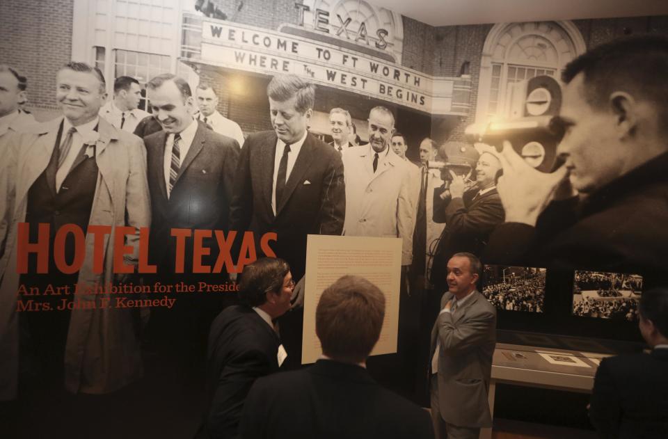 Curator Olivier Meslay, right, speaks with others at the entrance of the exhibit "Hotel Texas: An Art Exhibition for the President and Mrs. John F. Kennedy," during a press preview at the Dallas Museum of Art Wednesday, May 22, 2013, in Dallas. The exhibit reunites 14 of the 16 works that were placed in Suite 850 for the Kennedys' one-night stay in Fort Worth and includes photos of the suite before and after the artwork was placed there, video footage of the room being prepared for the Kennedys and historical artifacts from the visit, including a sign welcoming the Kennedys to Texas. (AP Photo/LM Otero)