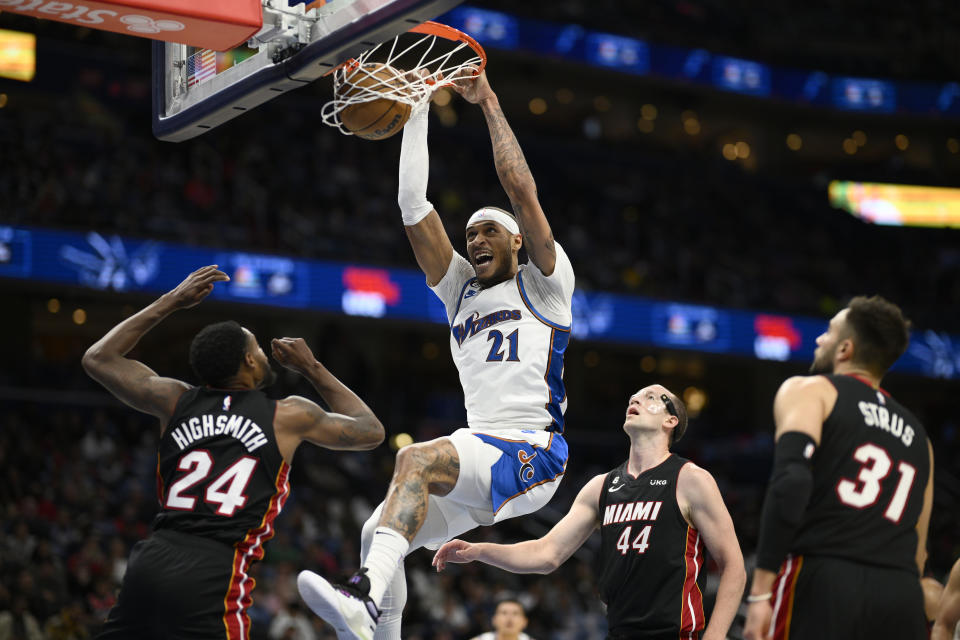 Washington Wizards center Daniel Gafford (21) dunks between Miami Heat forward Haywood Highsmith (24), center Cody Zeller (44) and guard Max Strus (31) during the first half of an NBA basketball game Friday, April 7, 2023, in Washington. (AP Photo/Nick Wass)