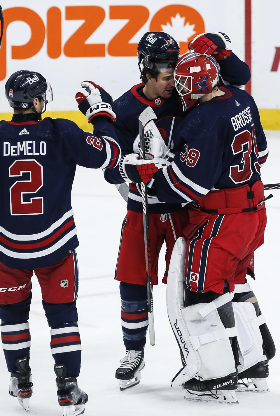 Winnipeg Jets' Dylan DeMelo (2) and Mark Scheifele (55) congratulates goaltender Laurent Brossoit (39) after defeating Arizona Coyotes in an NHL hockey game, Saturday, Nov. 18, 2023 in Winnipeg, Manitoba. (John Woods/The Canadian Press via AP)